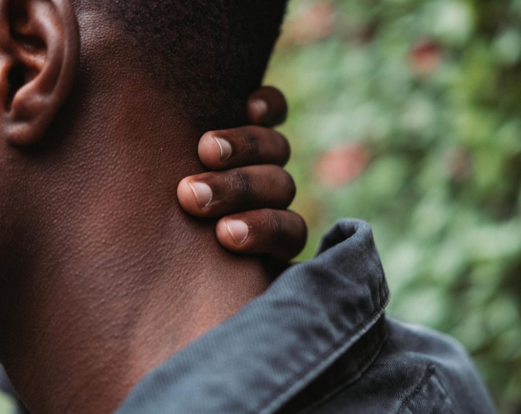 Man touching the back of his neck