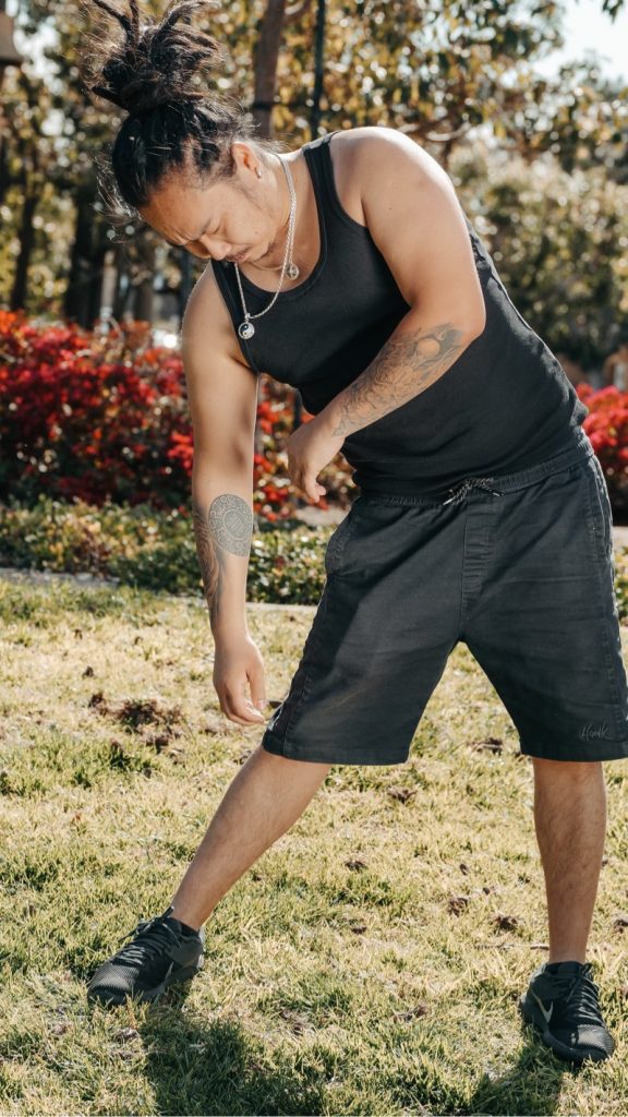 Man stretching outdoors while experiencing sciatica pain